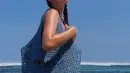 Alyssa Daguise berjemur menggunakan bikini. Namun tertutup oleh tas Raffia Tote dari seri Tropico milik Prada berwarna biru yang dijinjingnya. (instagram/alyssadaguise)
