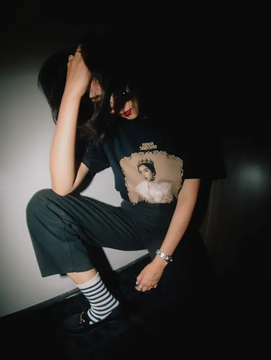 Gaya minimalis dengan kaus dan celana hitam terlihat seru dengan kaus kaki garis-garis (Foto: Instagram @isyanasarasvati)
