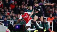 Gelandang Bayern Munich, Leon Goretzka (kanan) berebut bola dengan Bukayo Saka (Arsenal) selama pertandingan sepak bola leg pertama perempat final Liga Champions di Emirates Stadium, London, pada 9 April 2024. (Adrian DENNIS/AFP)