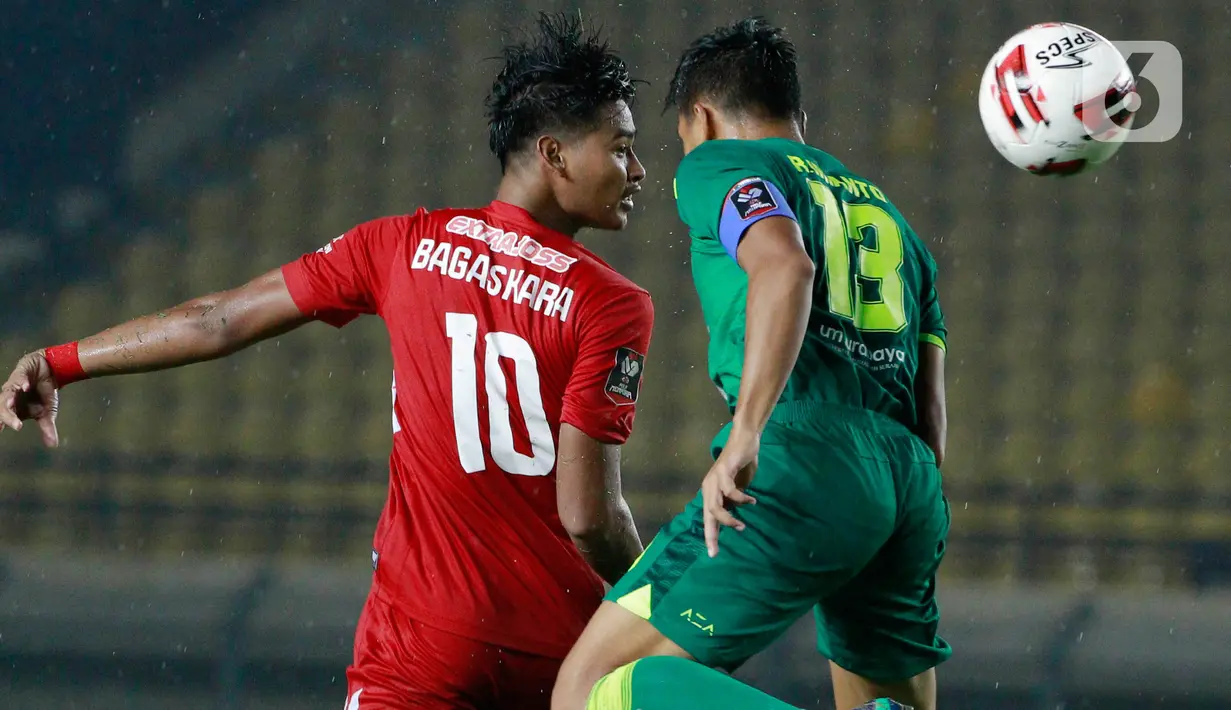 Bek Persebaya Surabaya, Rachmat Irianto (kiri), duel udara dengan pemain Persik Kediri, Bagaskara (kanan) pada laga Piala Menpora 2021 di Stadion Si Jalak Harupat, Bandung, Selasa (23/3/2021). Persebaya menang dengan skor 2-1. (Bola.com/M Iqbal Ichsan)