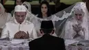 Vicky Prasetyo dan Angel Lelga membaca doa saat menggelar akad nikah di Mesjid Istiqlal, Jakarta, Jumat (9/2). Pasangan pengantin memilih gaun berwarna putih. (Liputan6.com/Faizal Fanani)