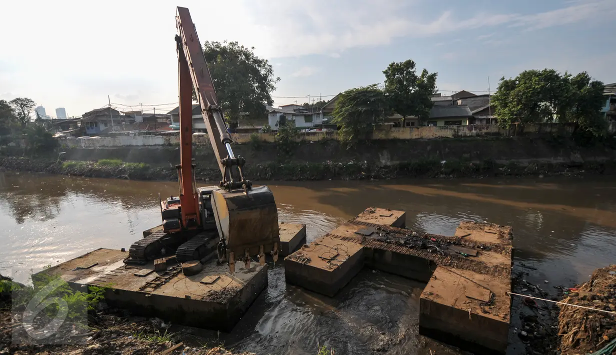 Alat berat melakukan pengerukan tumpukan sisa lumpur dan tanah yang menumpuk di pinggir kali Ciliwung, Jakarta, Kamis (28/7). Tumpukan tanah dan lumpur sisa dari pengerukan kali Ciliwung mulai dibersihkan.(Liputan6.com/Yoppy Renato)