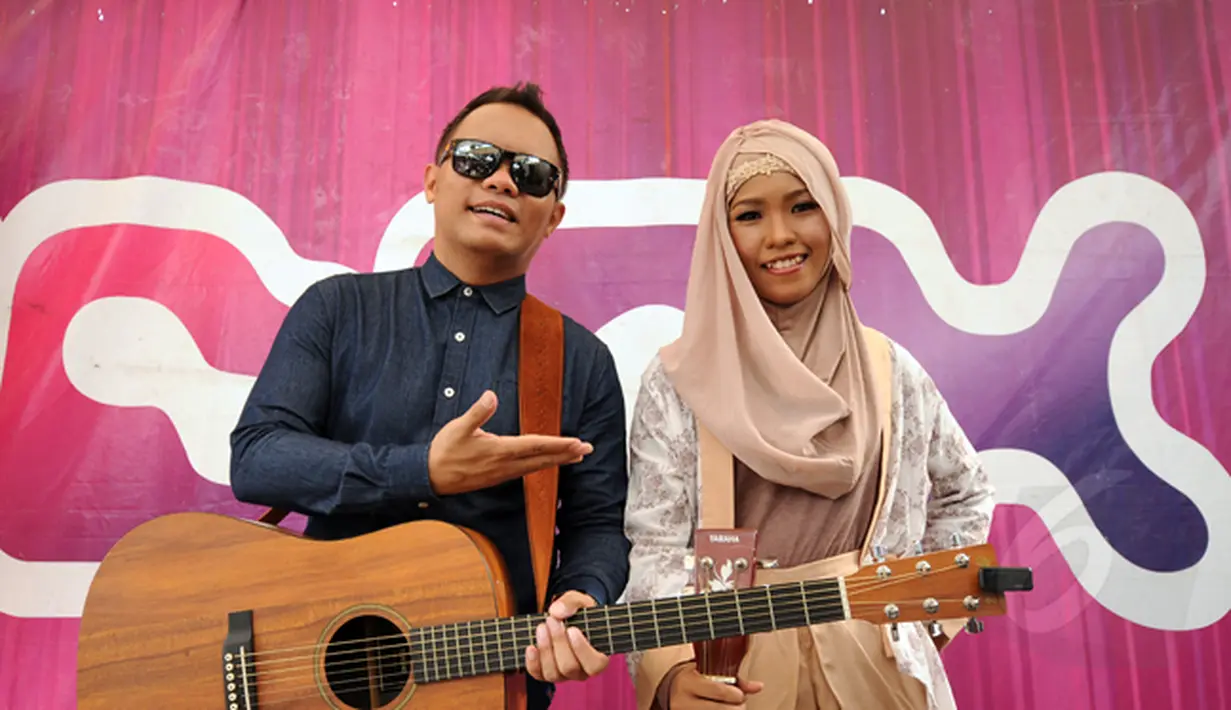 Juara Music Video Contest, Wiwi Handayani (kanan) berduet bersama Badai 'Kerispatih' di panggung inBox SCTV di Cibinong, Bogor, Jumat (30/1). Wiwi dan Badai berpose bersama usai tampil bersama di Cibinong Square, Bogor. (Liputan6.com/Helmi Fithriansyah)