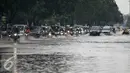 Sejumlah kendaraan melintasi genangan air dikawasan Kelapa Gading, Jakarta, Jumat (26/2/2016). Hujan deras yang mengguyur Ibukota membuat beberapa ruas jalanan tersendat. (Liputan6.com/Faizal Fanani)