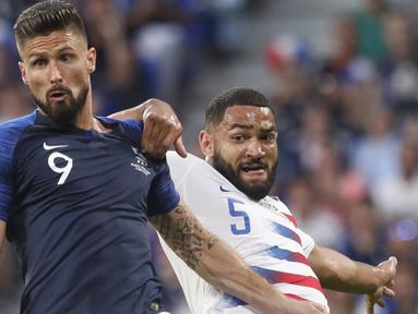 Pemain Prancis, Olivier Giroud (kiri) berebut bola dengan pemain Amerika Serikat, Cameron Carter-Vickers pada laga uji coba di Groupama stadium, Decines, Lyon (9/6/2018). Prancis dan Amerika bermain imbang 1-1. (AP/Laurent Cipriani)