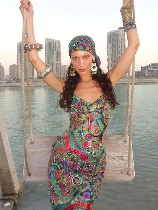 Pada potret ini, Bella Hadid tampil dengan gaya bohemian di pinggir pantai. Ia pun mengenakan satin dress bermotif tribal. [instagram/bellahadid]