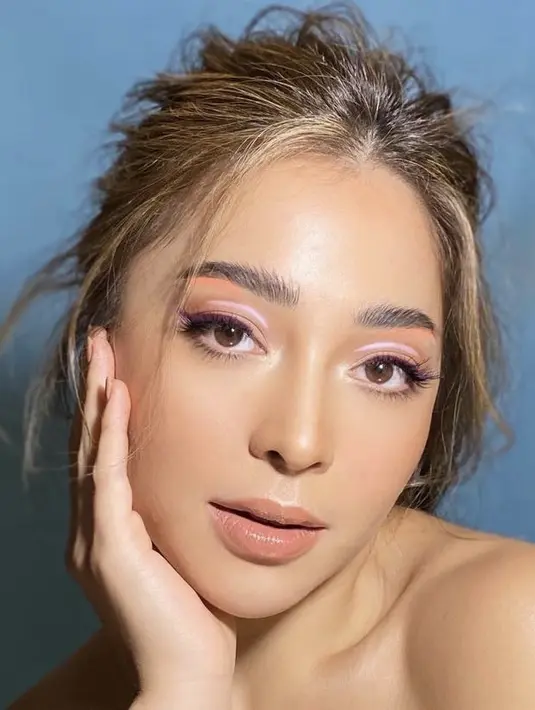Nikita Willy tampil apik mengenakan graphic liner coral di bawah bulu matanya, dan di bagian kelopak matanya dengan warna soft ungu. Dok instagram @archangelachelsea.