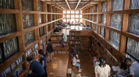 Dalam gambar pada 15 September 2018, orang-orang membaca di Perpustakaan Liyuan, pinggiran kota Beijing. Untuk membaca di sini, pengunjung harus mengantre lantaran gedung itu hanya boleh dimasuki oleh 40 orang. (FRED DUFOUR/AFP)