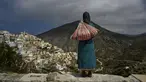 Foto yang diambil pada 6 Mei 2023 ini menunjukkan patung yang didedikasikan untuk perempuan Olympos, menghadap ke desa terpencil di pulau Karpathos. Di utara pulau Karpathos Yunani, desa lereng bukit Olympos adalah rumah bagi salah satu dari sedikit masyarakat matriarkal di Yunani yang menolak standardisasi pariwisata dan gaya hidup. (Louisa GOULIAMAKI / AFP)