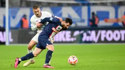 Pemain Paris Saint-Germain (PSG), Lionel Messi, diadang pemain Marseille, Valentin Rongier pada laga Piala Prancis di Stadion Stade Velodrome, Rabu (8/2/2022). Mereka takluk 1-2 saat berlaga di markas Marseille. (AFP/Christophe Simon)