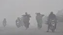Pengendara motor melintas saat kabut asap tebal di Lahore (21/11/2019). Dokter juga mengatakan orang yang merasakan dampak kabut asap harus minum banyak air, bilas mata mereka setidaknya sekali dalam satu jam, dan memakai masker wajah jika mereka harus bepergian ke luar. (AFP Photo/Arif Ali)