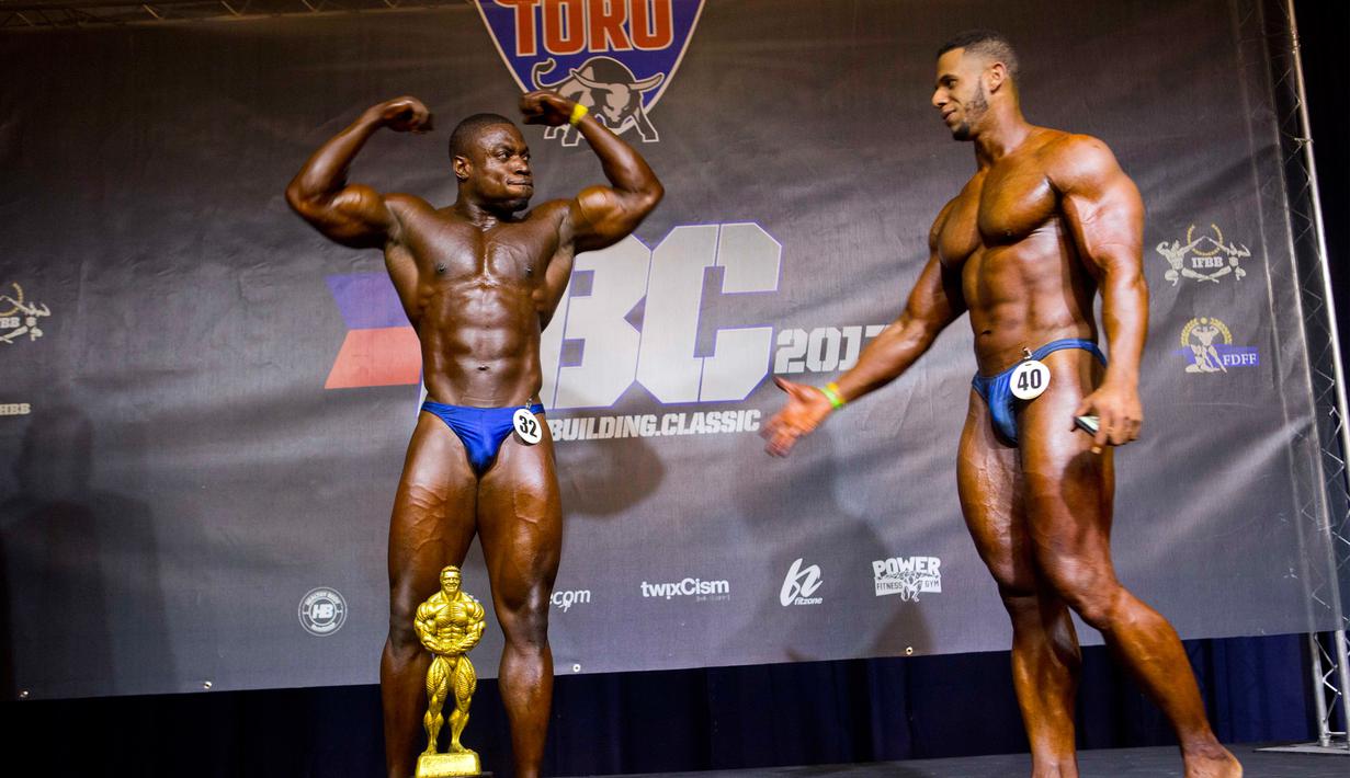 Binaragawan asal Dominika Emmanuel Hidalgo (kanan) memberi ucapan selamat atas kemenangan Spely Laventure binaragawan asal Haiti dalam kategori kelas berat di Port-au-Prince, Haiti, Minggu (23/7). (AP/Dieu Nalio Chery)