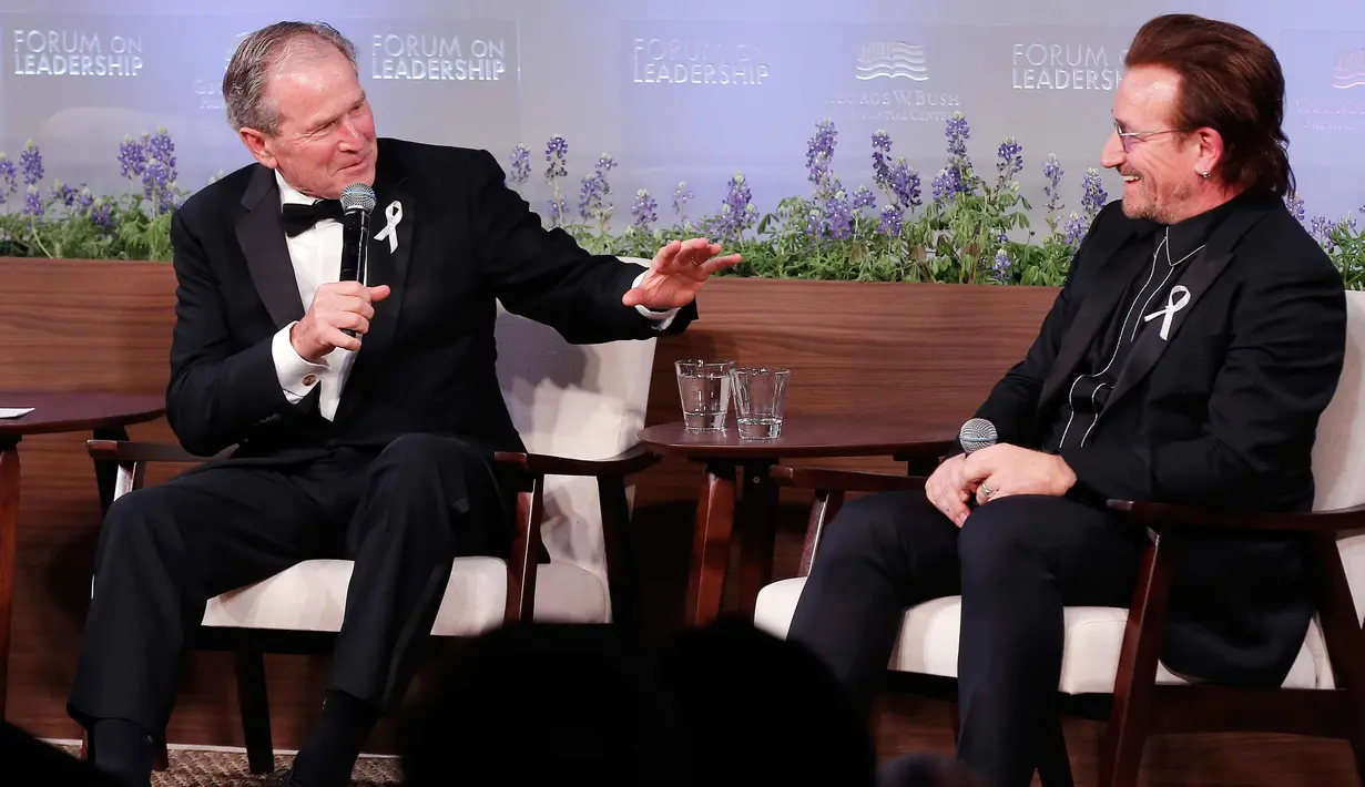 Presiden AS ke-43 George W. Bush berdiskusi dengan vokalis U2 Bono selama gala untuk Forum Kepemimpinan di Institut George W. Bush di Dallas, AS (19/4). Dalam acara ini Bush mempersembahkan Bono medali Distinguished Citizenship. (AP Photo/Brandon Wade)