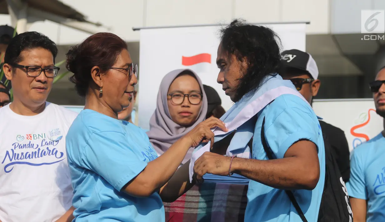 Menteri Kelautan dan Perikanan Susi Pudjiastuti memasangkan syal ke Kaka Slank saat meresmikan  'Pandu Laut Nusantara' sebagai wadah bersama untuk para pemerhati laut di CFD kawasan Bundaran HI, Jakarta, Minggu (15/7). (Liputan6.com/Arya Manggala)
