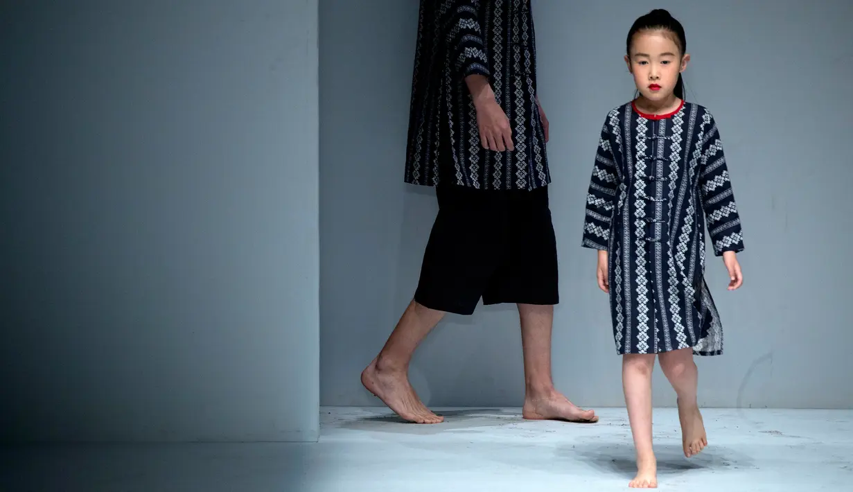 Model cilik berjalan di atas catwalk mengenakan koleksi busana orang tua dan anak YIAN karya Lu Enhua selama China Fashion Week di Beijing, Sabtu 1 April 2017. (AP Photo / Mark Schiefelbein)