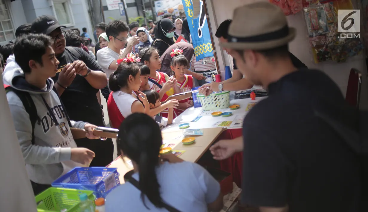 Pengunjung mengerubungi salah satu gerai yang terdapat di Festival Little Tokyo kawasan Blok M, Jakarta, Minggu (23/6/2019). Festival Little Tokyo menghadirkan berbagai jenis kuliner dan kebudayaan Jepang. (Liputan6.com/Faizal Fanani)