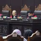 Hakim Mahkamah Konstitusi, Wahiduddin Adams (tengah) membacakan nota putusan perkara pengujian undang-undang tentang ASN, Sistem Pendidikan Nasional, Pendidikan dan Gelar Profesi, di Gedung MK, Jakarta, Kamis (14/2). (Liputan6.com/Helmi Fithriansyah)