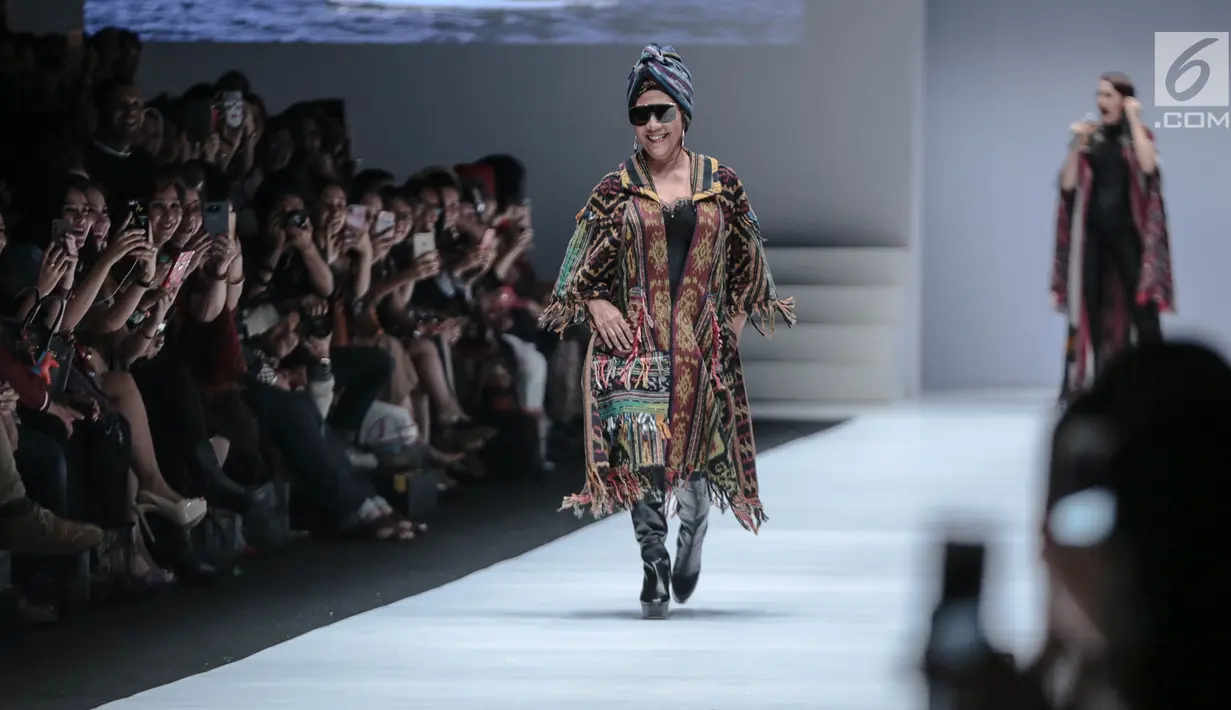 Menteri KKP, Susi Pudjiastuti memperagakan busana rancangan Anne Avantie pada Jakarta Fashion Week 2019 di Senayan City, Selasa (23/10). Tampilan Menteri Susi tampak nyentrik dengan kacamata hitam dan sepatu boots hak tinggi. (Liputan6.com/Faizal Fanani)