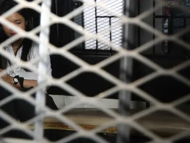 Jessica Kumala Wongso berada di dalam mobil tahanan usai sidang vonis di PN Jakarta Pusat, Jakarta, Kamis (27/10). Jessica mengatakan vonis yang dijatuhkan hakim tidak adil dan berencana akan mengajukan banding. (Liputan6.com/Helmi Afandi)