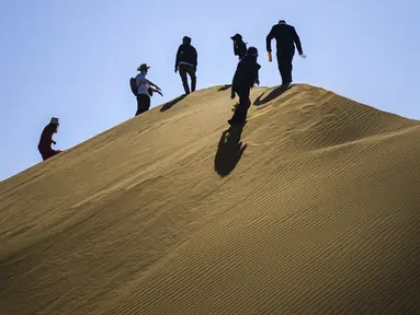 Para wisatawan mengunjungi kawasan wisata Gurun Kum Tag di Wilayah Shanshan, Kota Turpan, Daerah Otonom Uighur Xinjiang, China barat laut (22/9/2020). Gurun tersebut saat ini mencatat peningkatan arus wisatawan. (Xinhua/Wang Fei)