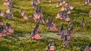 Aktivis dari COVID Memorial Project meletakkan ribuan bendera Amerika berukuran kecil di di halaman National Mall di Washington, Selasa (22/9/2020). Ribuan bendera itu menandai 200 ribu nyawa yang hilang akibat virus corona Covid-19 di Amerika Serikat. (AP Photo/J. Scott Applewhite)