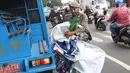 Petugas Satpol PP membawa APK usai diturunkan dari pagar pembatas di Jalan Raya Bogor dekat GOR Ciracas, Jakarta, Rabu (23/1). Penurunan APK ini karena pemasangannya dianggap melanggar ketentuan. (Liputan6.com/Helmi Fithriansyah)