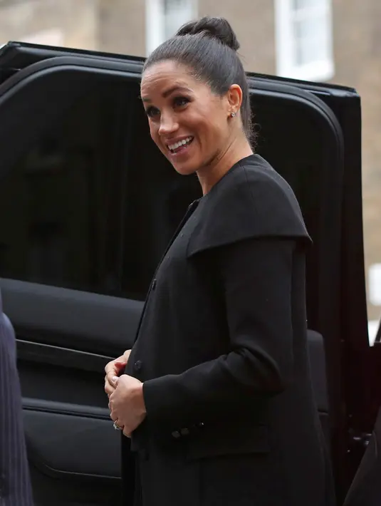 Duchess of Sussex, Meghan Markle bersiap masuk ke mobil seusai mengunjungi Association of Commonwealth Universities (ACU) di London, Kamis (31/1). Namun kali ini, Meghan Markle memilih untuk pergi tanpa tas di genggamannya. (Yui Mok/Pool Photo via AP)