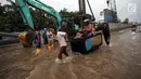 Sebuah sepeda motor diangkut menggunakan gerobak ketika banjir merendam di Jalan Boulevard Raya, Kelapa Gading, Jakarta, Kamis (15/2). Ketinggian banjir di kawasan ini mencapai 50 centimeter. (Liputan6.com/Arya Manggala)