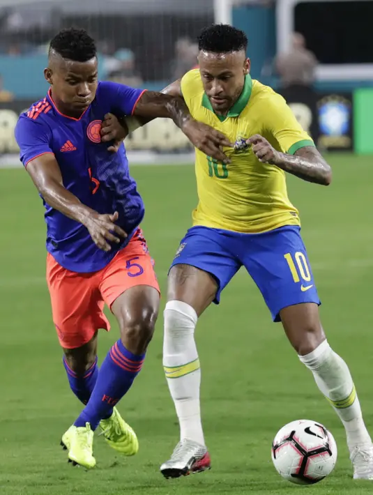 Penyerang Brasil, Neymar Jr menggiring bola dari kawalan gelandang Kolombia Wílmar Barrios selama laga uji coba di Hard Rock Stadium, Florida (7/9/2019). Brasil dan Kolombia bermain imbang 2-2. (AP Photo/Lynne Sladky)