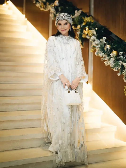 Gaya menawan Rossa kenakan lace dress warna putih dan turban warna grey. Aksen beads silver pada kerah dan lengan bikin looks Rossa semakin mewah. [@itsrossa910]