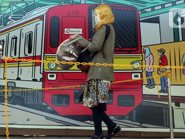 Calon penumpang KRL Commuterline menggunakan pelindung wajah dan masker saat di area pedestrian Stasiun Terpadu Tanah Abang, Jakarta, Kamis (27/8/2020). Guna menekan penyebaran Covid-19, aparat terkait terus menghimbau pentingnya menaati protokol kesehatan. (Liputan6.com/Helmi Fithriansyah)