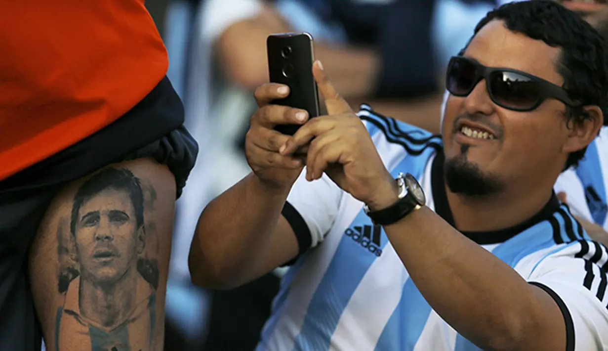 Seorang fan memotret tato Lionel Messi di Cile. (Reuters/Ivan Alvarado)