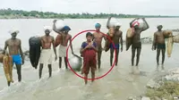 Wanita India yang seberangi sungai saat meluap. (BBC)