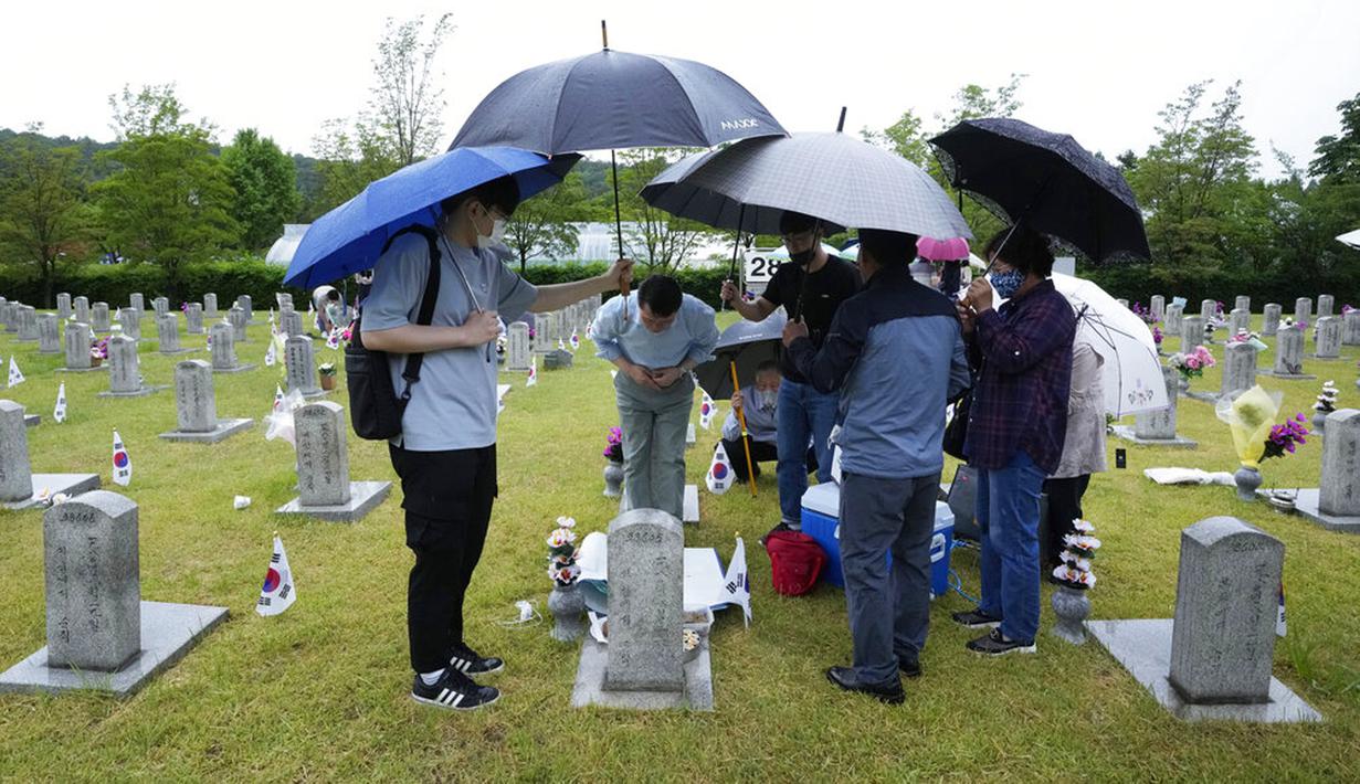 Anggota keluarga warga Korea Selatan yang meninggal saat Perang Korea Kim Yong-ho memberikan penghormatan di depan batu nisannya pada peringatan Hari Pahlawan di Pemakaman Nasional Seoul, Seoul, Korea Selatan, Senin (6/6/2022). (AP Photo /Ahn Young-joon)