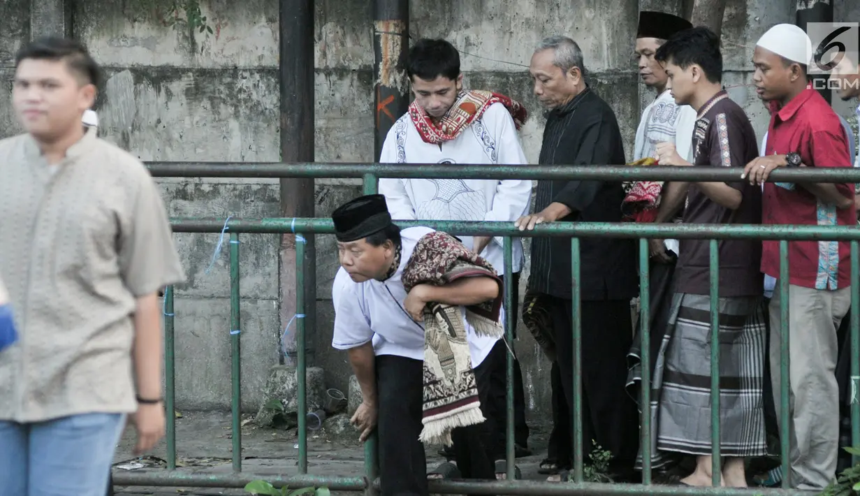 Sejumlah umat muslim menerobos pagar untuk menuju tempat pelaksanaan salat Idul Fitri 1438 H di kawasan Jatinegara, Jakarta, Minggu (25/7). Ruas Jalan Jatinegara Barat disulap menjadi tempat pelaksanaan salat Ied. (Liputan6.com/Yoppy Renato)