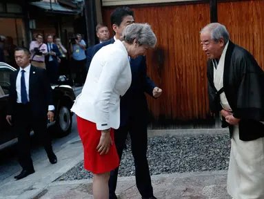 Perdana Menteri Inggris Theresa May (kiri) didampingi Perdana Menteri Jepang Shinzo Abe (tengah) memberi salam kepada Master of Tea Ceremony Sen Sosa di Kyoto, Jepang (30/8). (Kim Kyung-hoon/Pool Photo via AP)