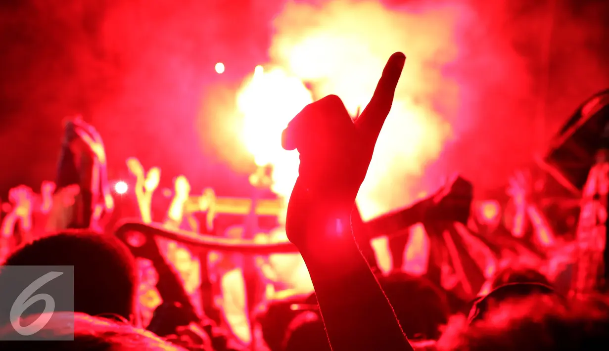 Pendukung Persebaya membuat tanda satu jiwa saat bernyanyi di GOR Padjajaran, Bandung, Sabtu (7/1). Suporter Persebaya berkumpul di GOR Padjajaran menunggu keputusan kongres PSSI terkait nasib klub kesayangan mereka. (Liputan6.com/Helmi Fithriansyah)