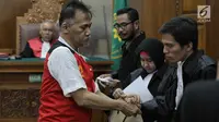Terdakwa kasus penyalagunaan narkoba, Tio Pakusadewo memeluk kuasa hukumnya saat sidang lanjutan di PN Jakarta Selatan, Kamis (12/7). Sidang beragendakan pembacaan duplik atas replik dari JPU pekan lalu. (Liputan6.com/Faizal Fanani)