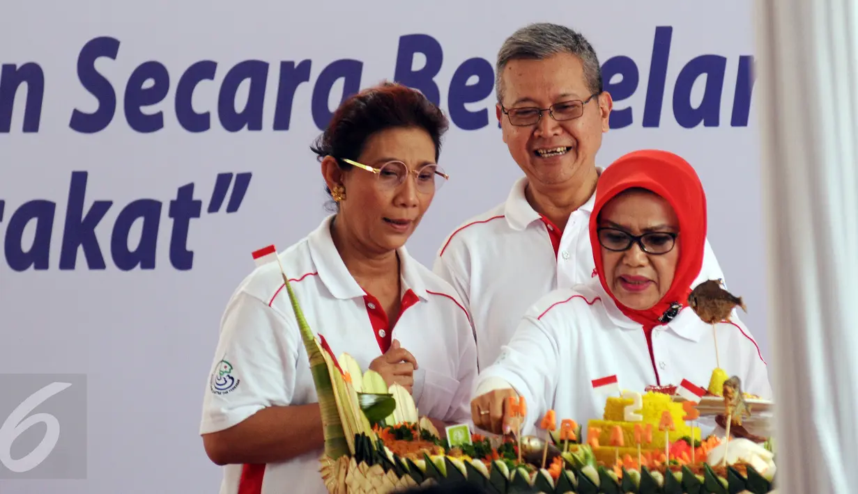 Ibu Wakil Presiden, Mufidah Jusuf Kalla (kanan) bersama Menteri Kelautan dan Perikanan, Susi Pudjiastuti memotong tumpeng pada puncak peringatan Hari Ikan Nasional ke-2 di Jakarta, Minggu (22/11/2015).(Liputan6.com/Helmi Fithriansyah)