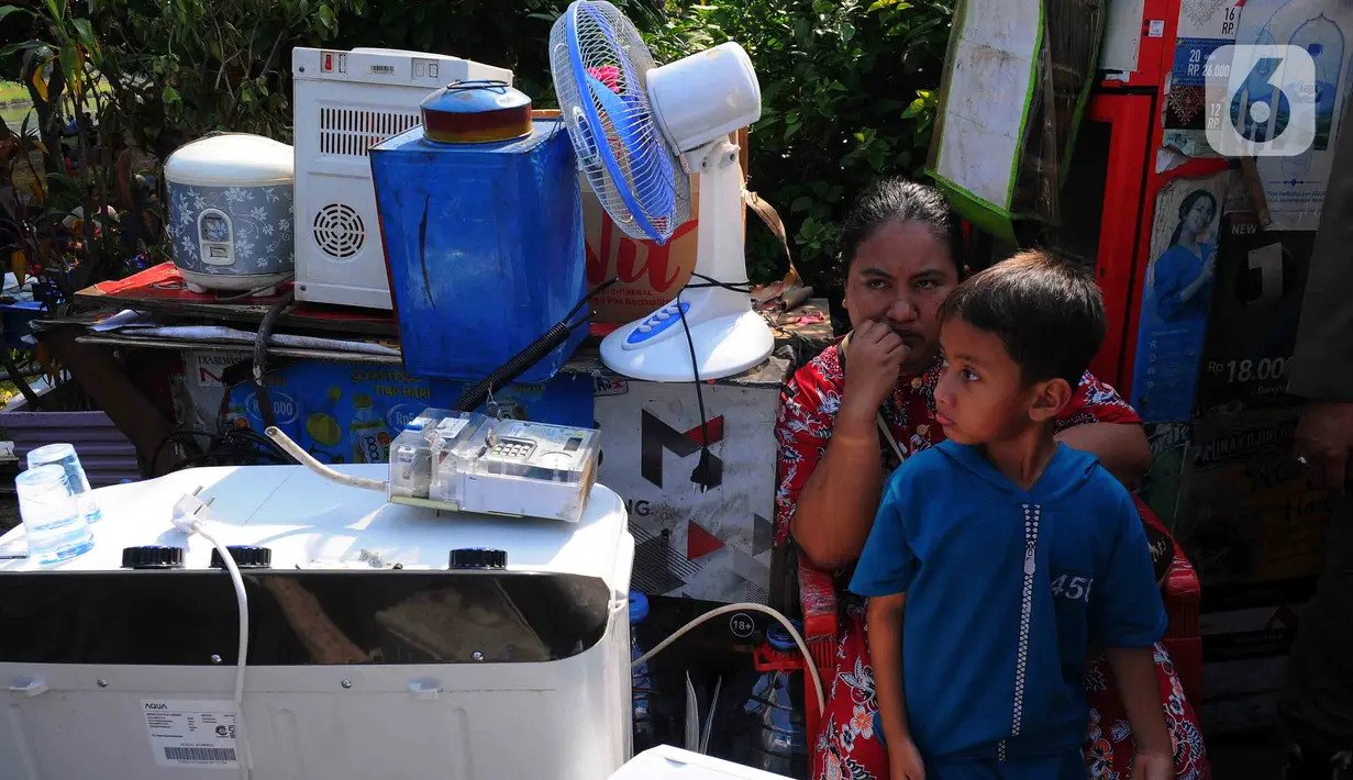 Warga duduk dekat barang-barang saat bangunannya terdampak proyek sodetan Ciliwung menuju Kanal Banjir Timur (KBT) di Kelurahan Cipinang Besar Selatan, Jakarta, Kamis (12/1/2023). Pemprov DKI mempercepat pembangunan sodetan kali Ciliwung menuju Kanal Banjir Timur (KBT) dengan tujuan mampu mengurangi dampak banjir dengan volume 60 kubik per detik. (merdeka.com/Imam Buhori)