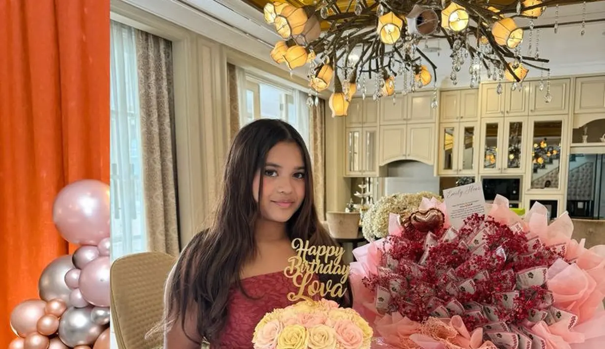 Saat mendapatkan kejutan buket bunga dan kue ulang tahun, Arlova mengenakan atasan merah bertekstur strapless dipadukan celana hitam pleated. [@erintaulany]