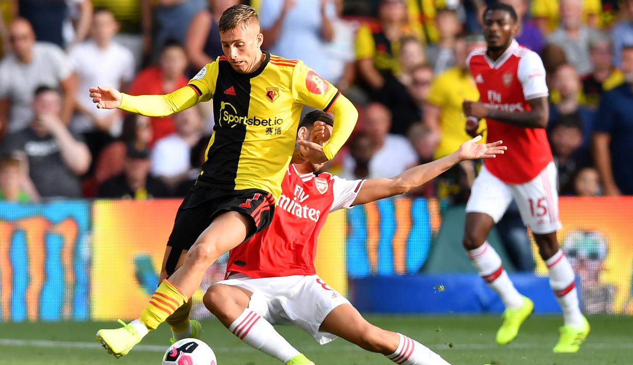 Gelandang Watford, Gerard Deulofeu, menghindari tekel gelandang Arsenal, Dani Ceballos, pada laga Premier League 2019/20 di Stadion Vicarage Road, Watford, Minggu (15/9). Kedua klub bermain imbang 2-2. (AFP/Ben Stansall)