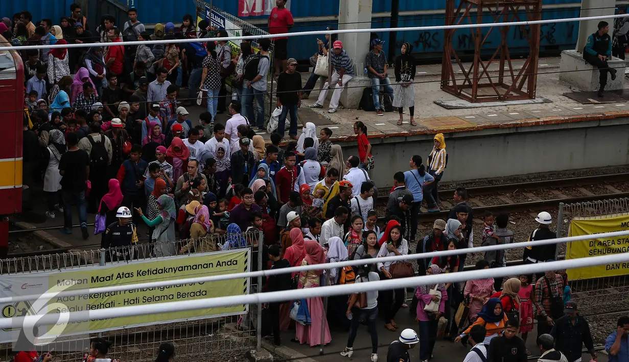 Puluhan calon penumpang melintasi rel kereta api di Stasiun Tanah Abang, Jakarta, Senin (11/7). Stasiun Tanah Abang mulai ramai di awal kerja usai libur lebaran. (Liputan6.com/Faizal Fanani)