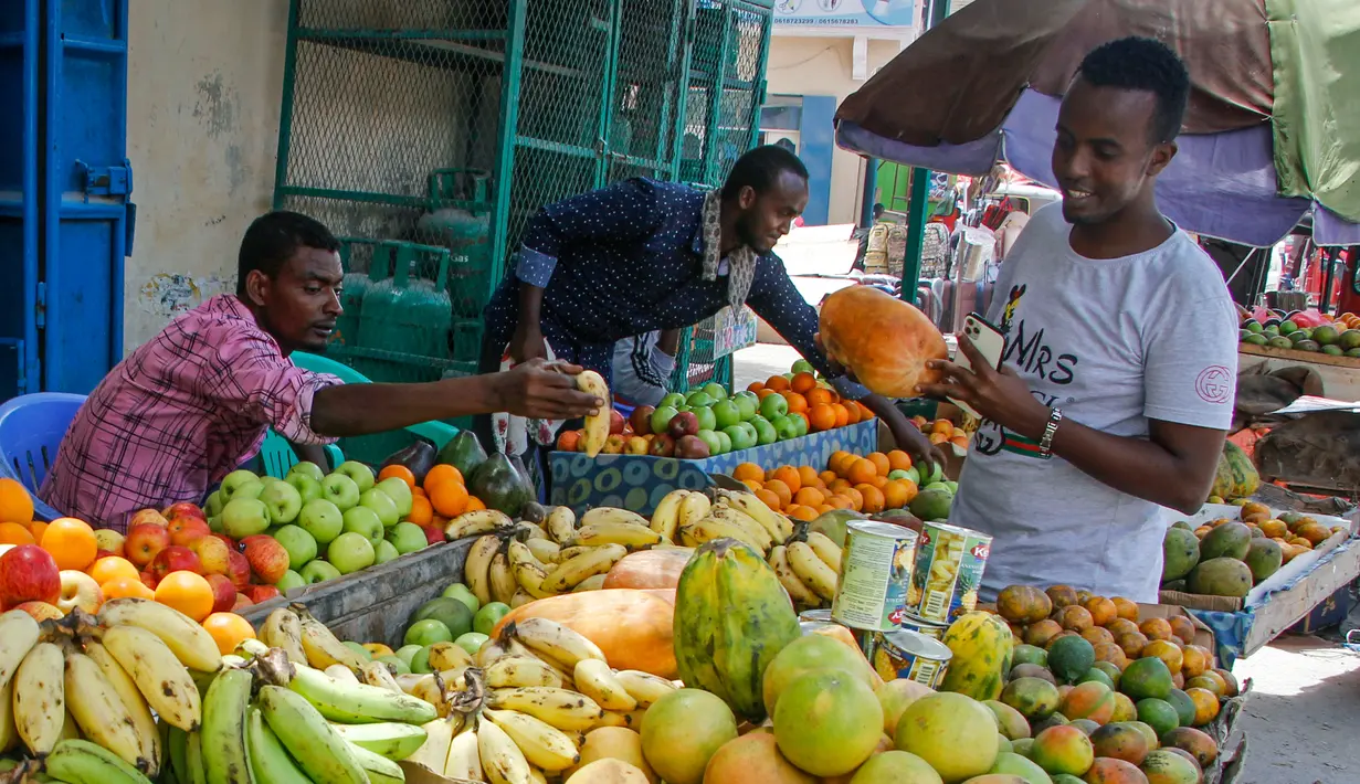 Seorang pelanggan memeriksa buah di pasar jalanan ketika keluarga berbelanja untuk liburan Muslim Idul Fitri, yang menandai akhir bulan puasa Ramadhan, di Mogadishu, Somalia, (19/5/2020). (AP Photo/Farah Abdi Warsameh)