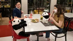 Pelanggan duduk di sebelah boneka panda untuk menjaga jarak di restoran Maison Saigon di Bangkok, Rabu (13/5/2020). Pemerintah Thailand sudah memberlakukan pelonggaran lockdown atau pembatasan wilayah sehingga sejumlah restoran dan toko-toko dapat beroperasi kembali seperti biasa. (AP/Sakchai Lalit)