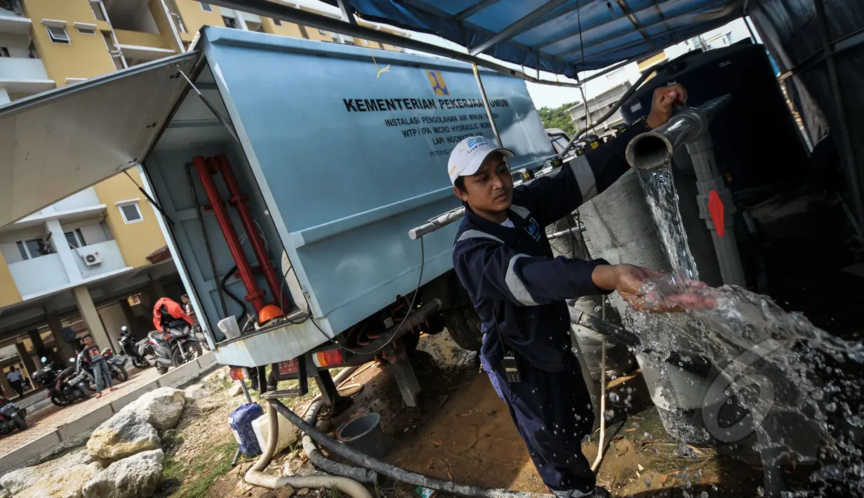Petugas menunjukkan air bersih dari hasil sulingan di Rusun Muara Baru, Jakarta, Rabu (22/4/2015). Minimnya air bersih di rusun tersebut membuat kementerian pekerja umum menyediakan alat penyulingan air . (Liputan6.com/Faizal Fanani)