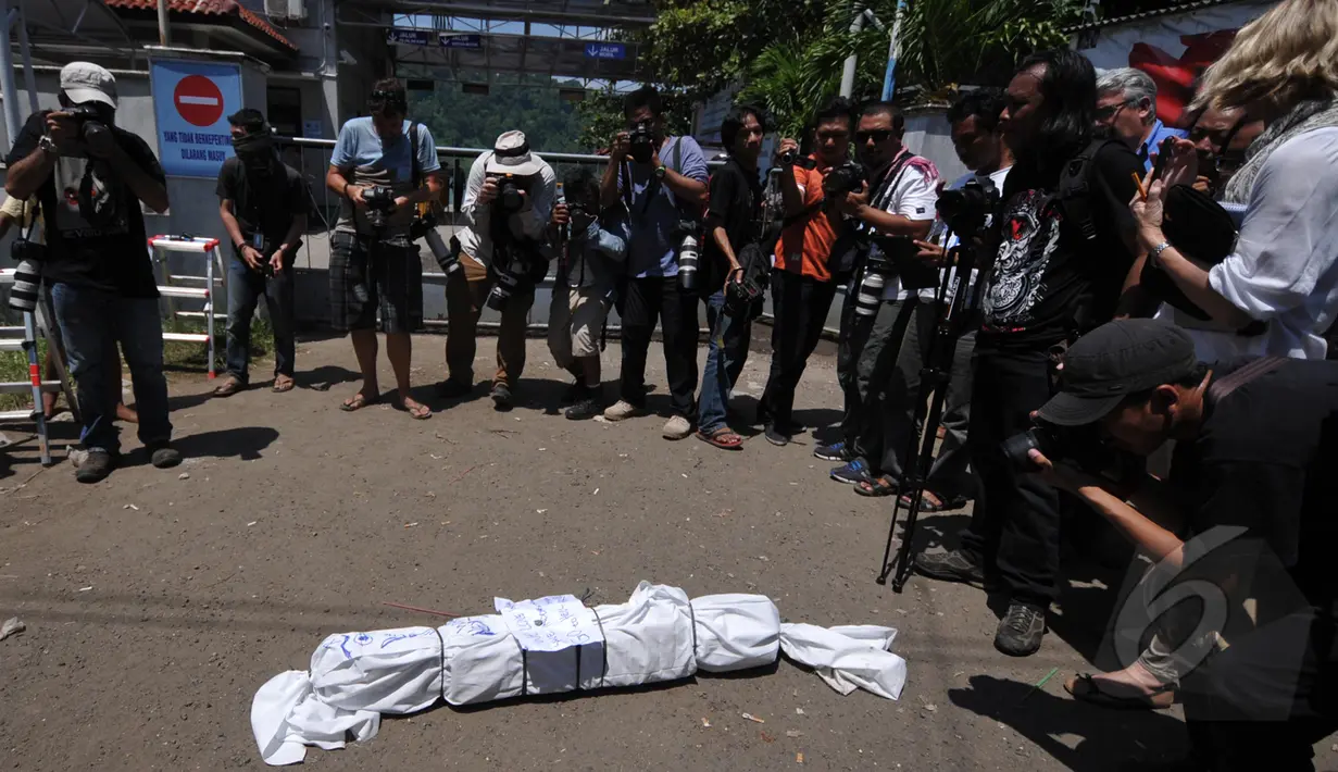Sejumlah wartawan mengabadikan aksi demonstrasi massa dari Granat di depan pintu masuk Dermaga Wijaya Pura, Cilacap, Jateng, Jumat (6/3). Massa menuntut Kejagung segera mengeksekusi mati gembong narkoba Bali Nine. (Liputan6.com/Johan Tallo)