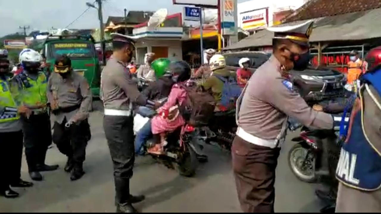 Petugas Satlantas Polres Tasikmalaya, Jawa Barat tengah membagikan selembaran termasuk masker kepada pengguna jalan, sebagai upaya sosialisasi larangan mudik 2021 yang disampaikan pemerintah pusat beberapa waktu lalu.