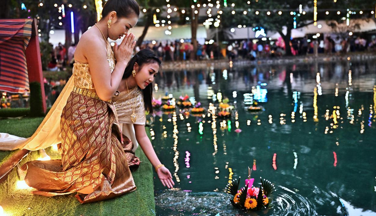 <p>Orang-orang melepaskan lampion mengambang di kolam selama festival Loy Krathong di Bangkok (8/11/2022). Loy Krathong merupakan sebuah nama untuk festival perayaan akhir tahun yang biasa dihelat di seantero negri Thailand. (AFP/Lillian Suwanrumpha)</p>