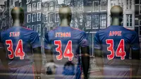 Tiga jersey dukungan untuk Gelandang  Ajax Amsterdam, Abdelhak Nouri, terpampang di depan toko, Amsterdam, Kamis (13/7/2017). Pemain berusia 20 tahun ini terancam harus mengakhiri kariernya karena mengalami kerusakan otak permanen. (AFP/Bart Maat)